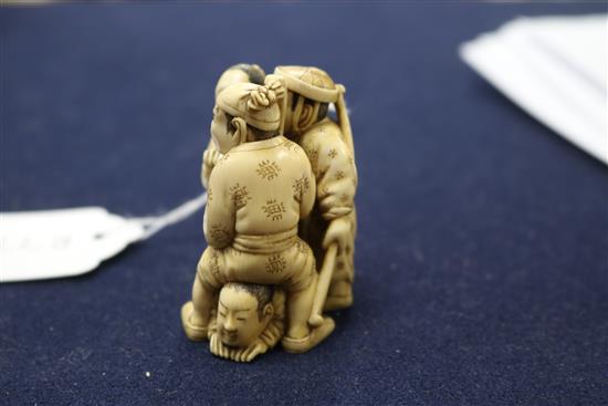 A Japanese ivory okimono carved with three figures height 6.5cm